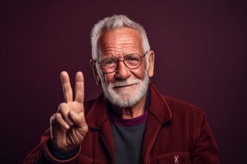 Obraz premium Headshot portrait photography of a glad old man making an ok gesture with the fingers against a burgundy red background. With generative AI technology