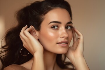 Close-up portrait photography of a glad girl in her 30s making a i'm listening gesture with the hand on the ear against a beige background. With generative AI technology