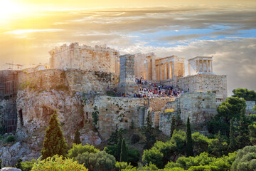 A Dramatic sunset over the antique Acropolis of Athens. Tourists wander about the Athenian Acropolis in the morning in Athens, Greece