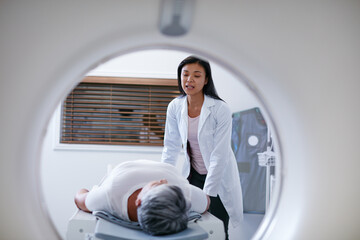 Doctor, mri and woman with patient in hospital ready to start scanner machine. Ct scan, examination and medical professional with senior person before cancer radiology test for healthcare in clinic. - obrazy, fototapety, plakaty