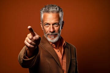 Medium shot portrait photography of a satisfied mature man pointing at oneself with the index finger against a copper brown background. With generative AI technology