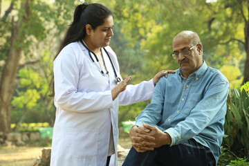 Indian female doctor checking the body temperature of the patient by using a thermometer.