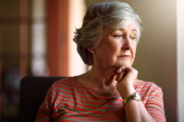 Senior woman, worry and thinking at window with memory, ideas and home on living room sofa. Elderly...