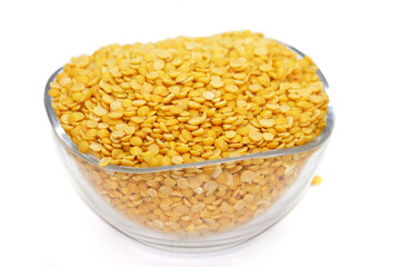 Yellow lentil in glass bowl isolated on white background with clipping path. To prepare a traditional vegetarian Indian spiced soup-puree chana dal.