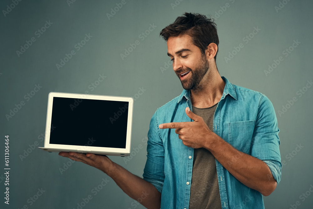Poster happy man, laptop and pointing to mockup screen for advertising or marketing against a grey studio b