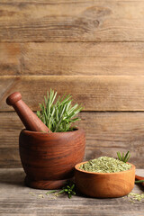Fresh and dry rosemary on wooden table