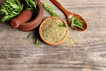 Fresh and dry rosemary on wooden table, flat lay. Space for text