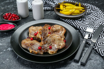 Tasty beef tongue pieces served on dark table