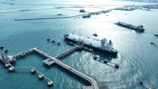 LNG (Liquified Natural Gas) tanker anchored in Gas terminal gas tanks for storage. Oil Crude Gas Tanker Ship. LPG at Tanker Bay Petroleum Chemical or Methane freighter export import transportation and