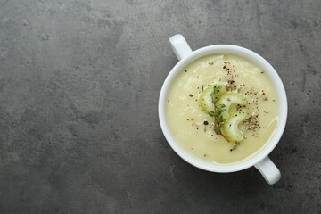 Bowl of delicious celery soup on gray table, top view. Space for text