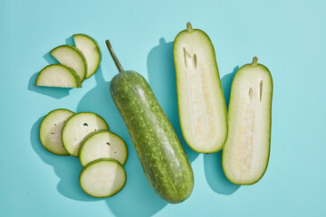 Natural fresh fruit concept with winter melon cut in half and slices over light blue background. The antioxidants in Winter melon (Benincasa hispida) help reduce oxidative stress