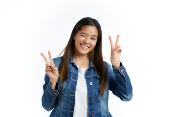 young asian woman with victory gesture isolated on white background with denim jacket