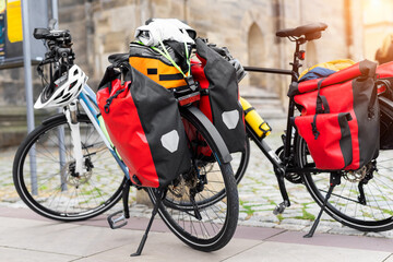 Many modern bicycles with travel luggage bags equipment parked in old european city center street....