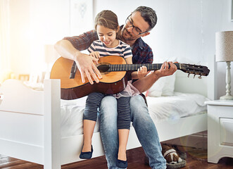 Bedroom, teaching and guitar with father, girl for fun with music at the house for bonding. Instrument, acoustic and learning with parent, child in room with happiness or love or creativity at house.
