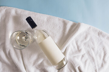 Bright white beach towel with bottle and glass cold wine drink. Minimal aesthetic refreshment...