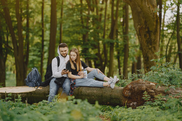 Cute couple have a rest in a summer forest