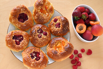 Homemade yeast rolls with fresh fruit: raspberries, strawberries, apricots