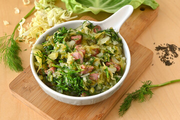 Stewed young cabbage with dill and sausage