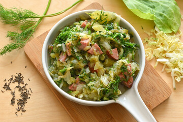 Stewed young cabbage with dill and sausage
