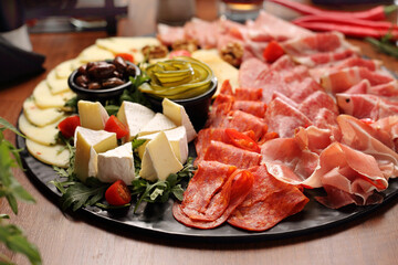 Appetizers buffet with tasty meat snacks, pickles, close-up. Cheese and cold cuts board, tapas. 