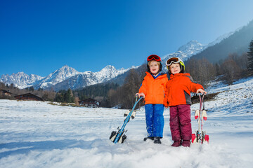 Boy and girl at their first alpine getaway in helmets, ski masks