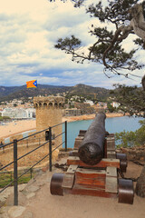 An old cannon, in the castle of Tossa de Mar, points towards the bay