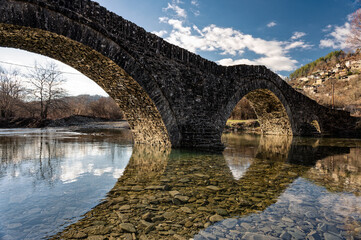 View of the traditional stone Mylos Bridge in Zagori of Epirus, Greece. © dinosmichail