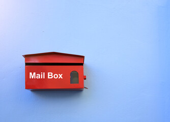 Red mail box install on the blue wall. Document or paper information transfer concept.