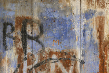 Old scratched wood abstract background - old blue color painted weathered wooden plank with grafity and carved letters