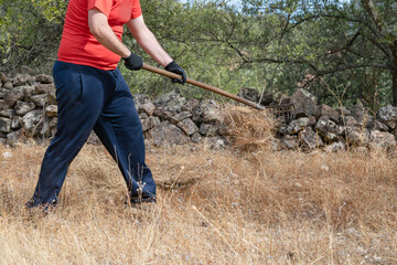 Country man raking dry weeds. Motion blur. Rural activity.
