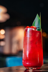 Glass with tropical juice lemonafe with fruits on table
