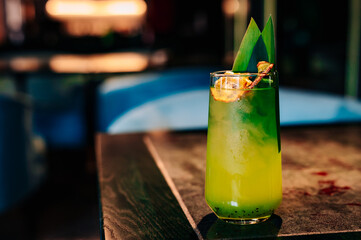 Glass with tropical juice lemonafe with fruits on table