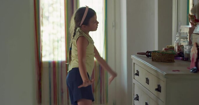 Portrait of Little Girl in her Room Practicing a Dancing Routine In Front of a Mirror During Day. Slow Motion of Female Child Playing at Home, Listening to Music and Putting a Show
