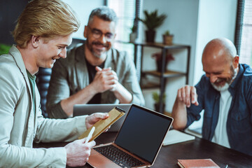Happy business team sits together in office, engaged in lively conversation. Teamwork and collaboration evident they communicate and discuss important matters. Professional and productive workplace