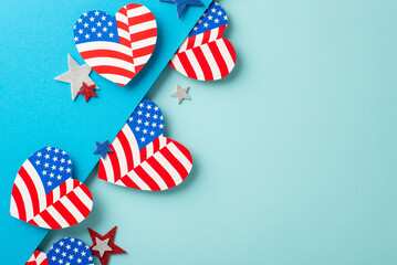 Fourth of July USA imaginative felicitations. Top view of emblematic embellishments: hearts adorned with American flag pattern, glittering stars on bicolor soft blue surface with space for text or ad