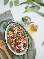 Fresh and healthy food, summer salad. Mediterranean watermelon salad with cheese, cucumber and basil leaves .