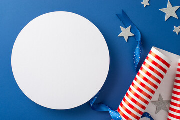 Preparing for USA's Independence Day extravaganza. Top view of patriotic-themed gift wrap, ribbon, sparkling stars add flair to vibrant blue backdrop, with empty circle for text or promotional content