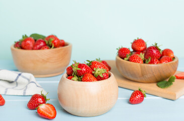 Fresh strawberries in bowl on wooden table