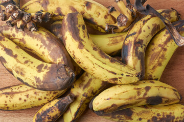 bunch of over ripe or black spotted banana, rotten or spoiled, unappealing and overly brown with...