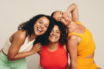 Happy female friends smiling at the camera as they celebrate a healthy lifestyle