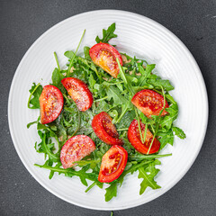 tomato salad plate arugula, grated cheese, olive oil healthy meal food snack on the table copy space food background rustic top view 