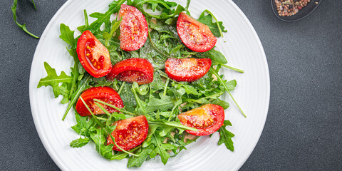 tomato salad plate arugula, grated cheese, olive oil healthy meal food snack on the table copy space food background rustic top view 