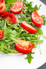 tomato salad plate arugula, grated cheese, olive oil healthy meal food snack on the table copy space food background rustic top view 