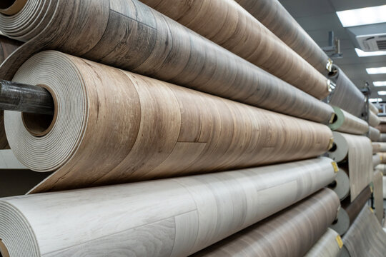 Rolls of new linoleum on the window of a hardware store. A large selection of linoleum