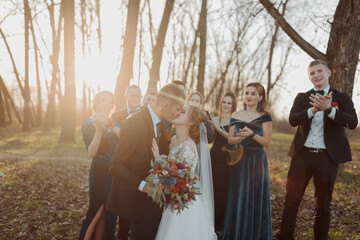 Brides and friends in the nature. Friends at the wedding. Newlywed couple, bridesmaids and...