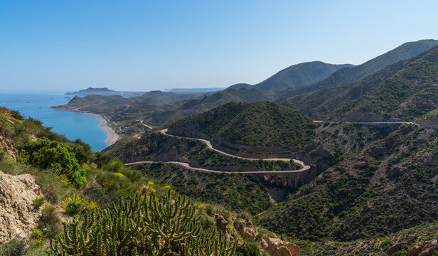 A winding road on the east coast of Spain Murcia mountains, blue sea and ship, Costa del Sol. A beautiful road along the sea with steep cliffs. View of the blue sky and the sea.