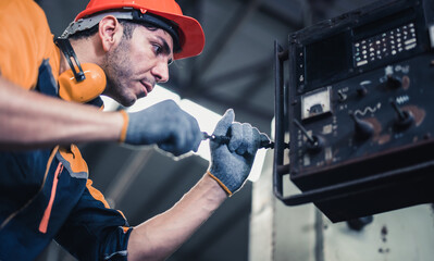Skilled mechanical technicians tighten, loosen components with screwdriver to perform safety...