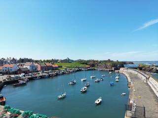 Fototapeta na wymiar Aerial view of Dunbar harbour with boats docked and a clear blue sky background. Dunbar Scotland. 