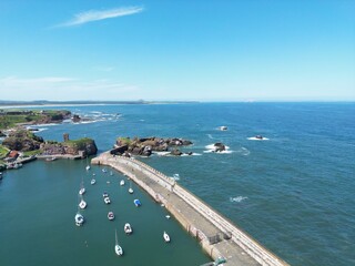 Fototapeta premium Aerial view of Dunbar harbour with boats docked and a clear blue sky background. Dunbar Scotland. 