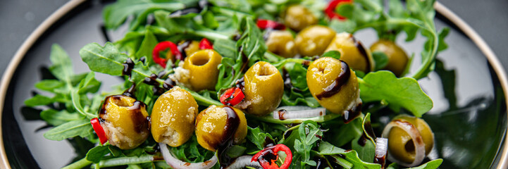 salad olives, hot chili peppers, green mix lettuce, arugula healthy meal food snack on the table copy space food background rustic top view keto or paleo diet veggie vegan or vegetarian food